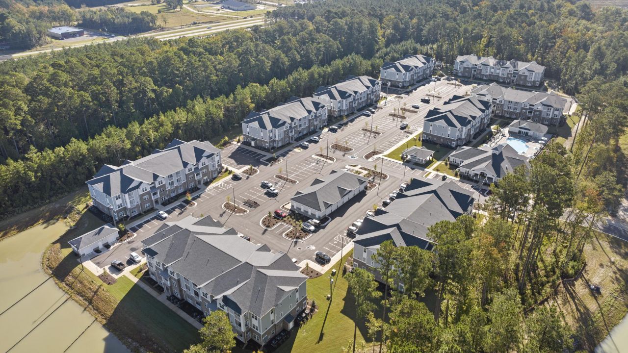 Aerial view of the Hudson at Carolina Colours apartments, showcasing their proximity to the serene lake and surrounding greenery.
