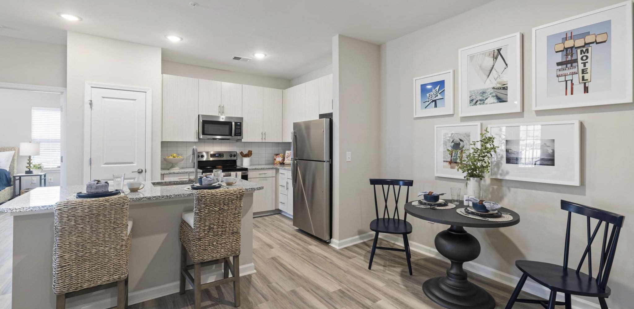 Hudson at Carolina ColoursA modern kitchen and dining area in a new apartment island with chairs, stainless steel appliances, and a large sink
