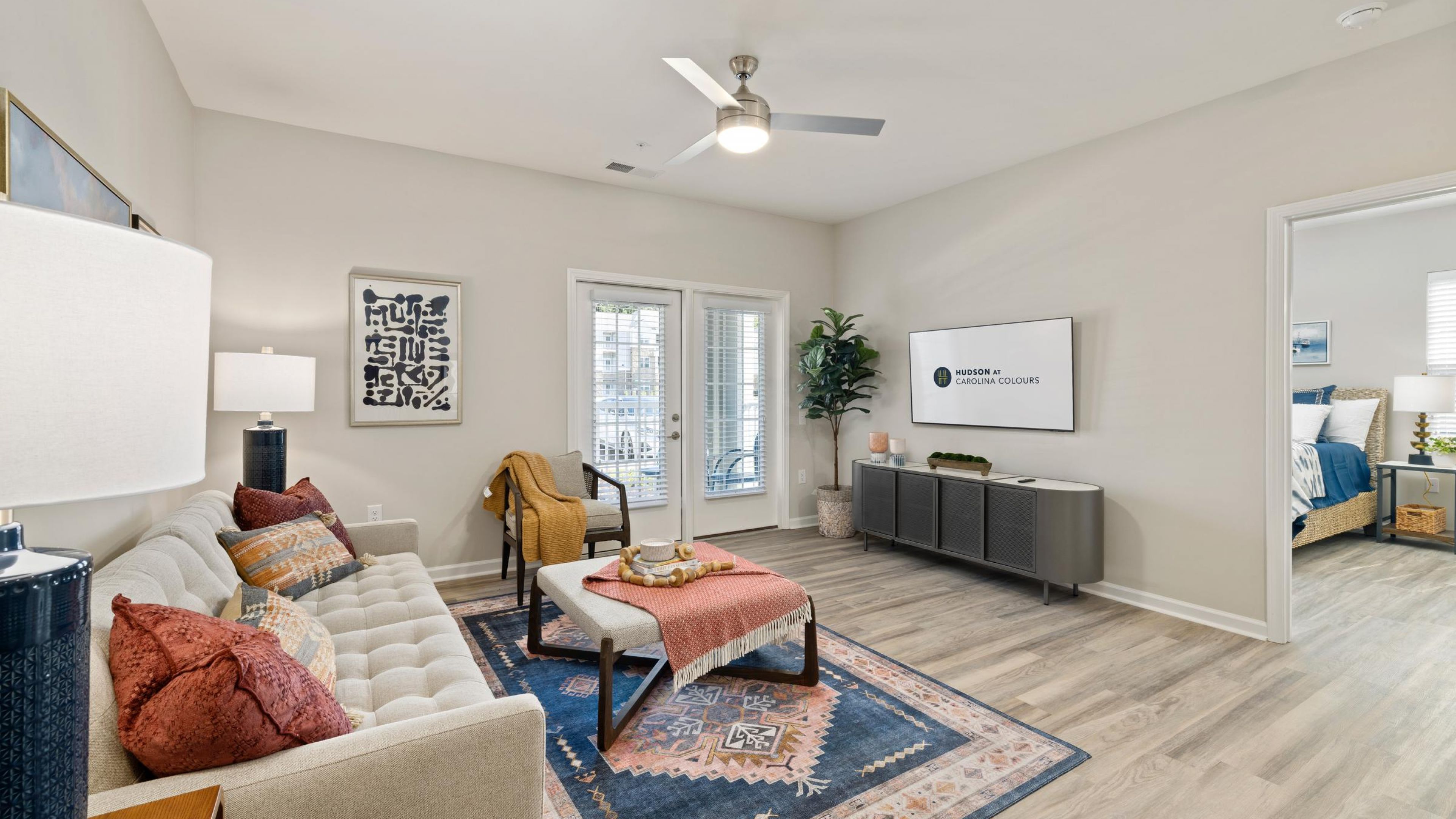 Hudson at Carolina ColoursA cozy living room featuring a couch, coffee table, and a television against a neutral wall